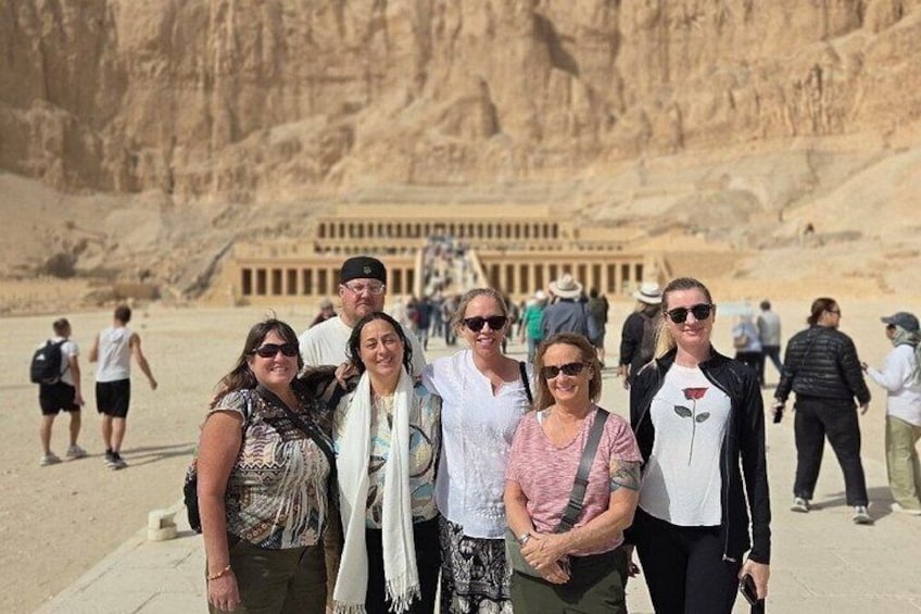 Een groep toeristen voor een groot, oud Egyptisch tempel met hiërogliefen. 2