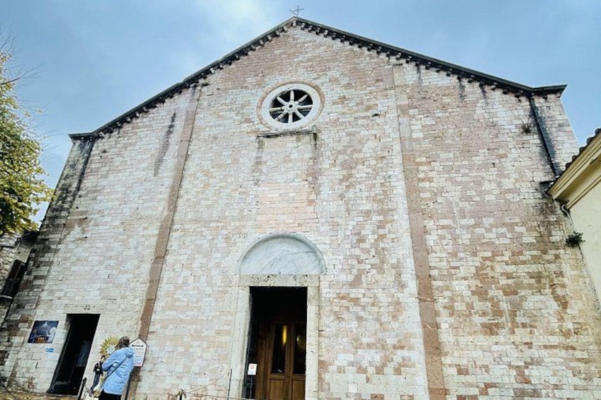 A historic church with a bell tower, arched entrance, and a circular window. 5