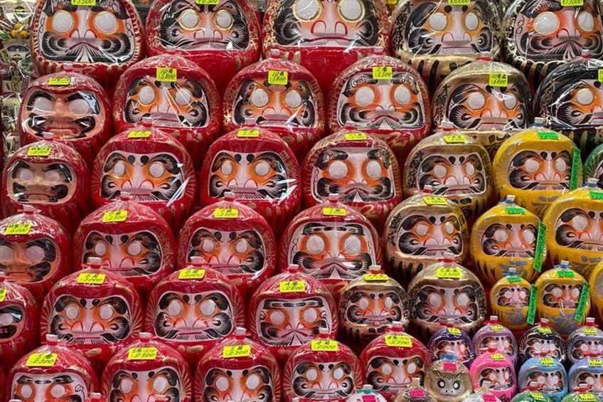 Een verzameling traditionele Japanse poppen, gerangschikt in rijen, met verschillende gezichtsuitdrukkingen. 4