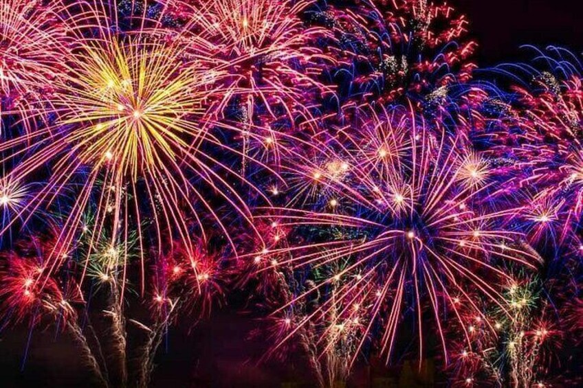 A night sky with multiple fireworks exploding in various colors. 1