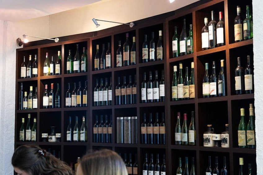 Una bodega con numerosas botellas organizadas en estanterías de madera. 4