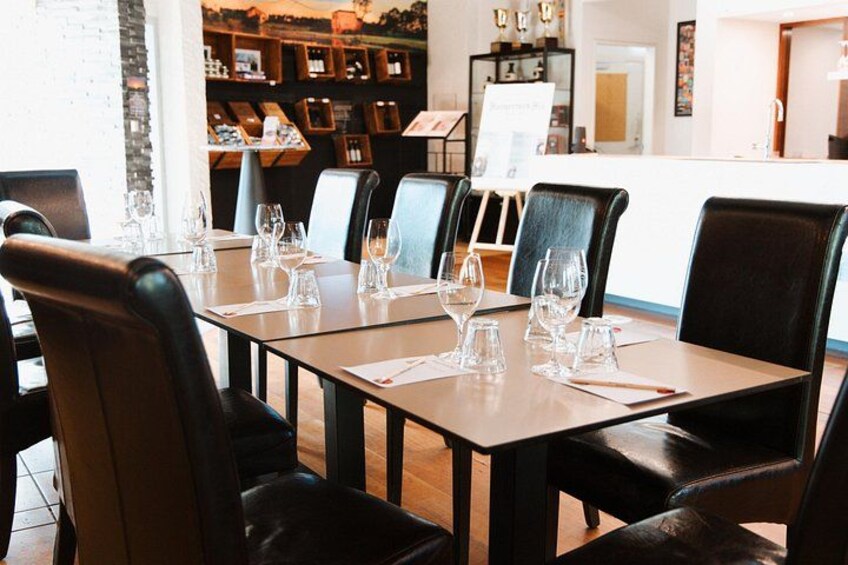 Un interior de restaurante con mesas dispuestas para comer, sillas y una barra de fondo. 2