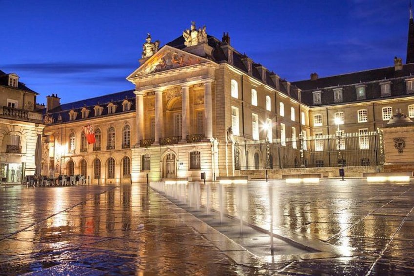 A historic building with classical architecture, a courtyard, and a reflective water surface. 4