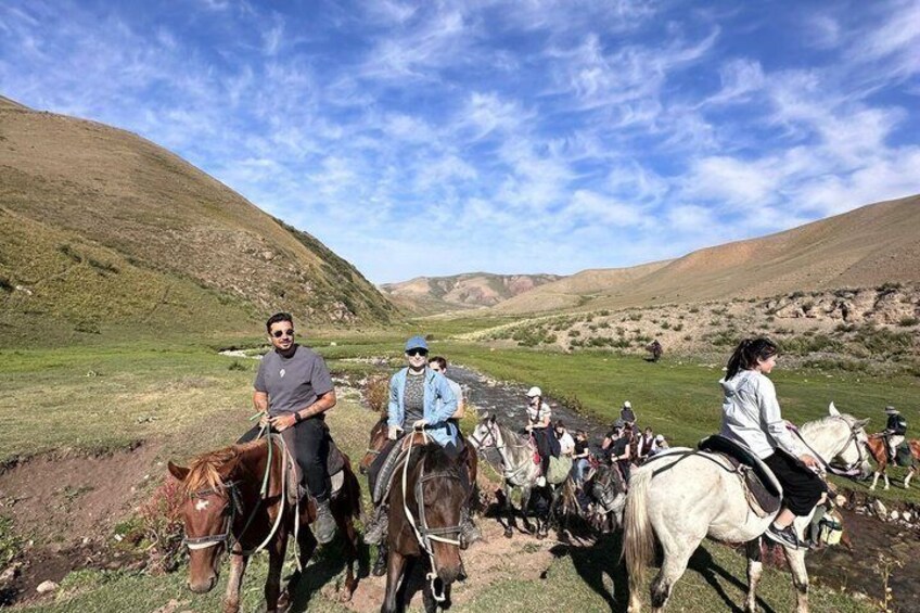 Un grupo de personas montando a caballo en una ladera cubierta de hierba. 5