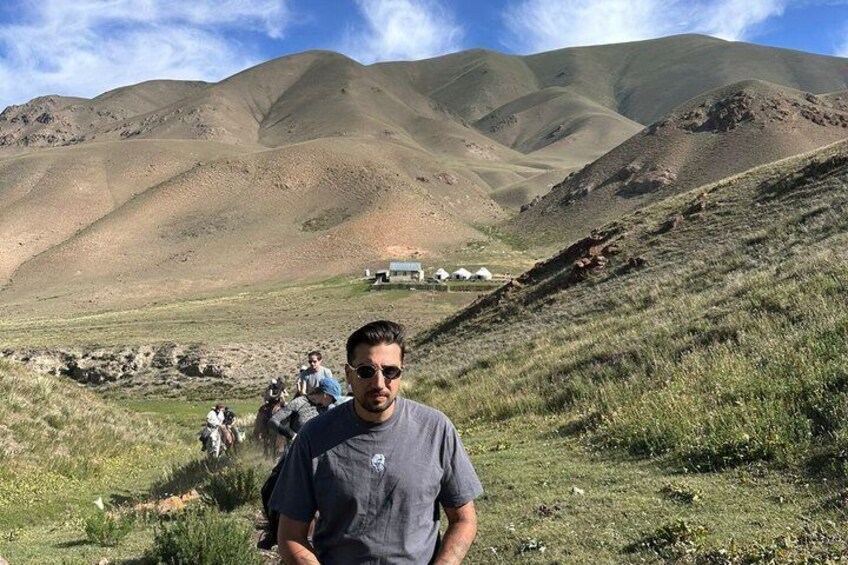 Paisaje montañoso con tiendas de campaña y gente. 3