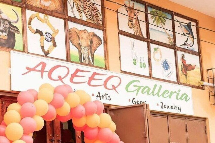 En butiksfasad med en skylt som visar texten ”Aquee Gallery” och en uppsättning ballonger. 3