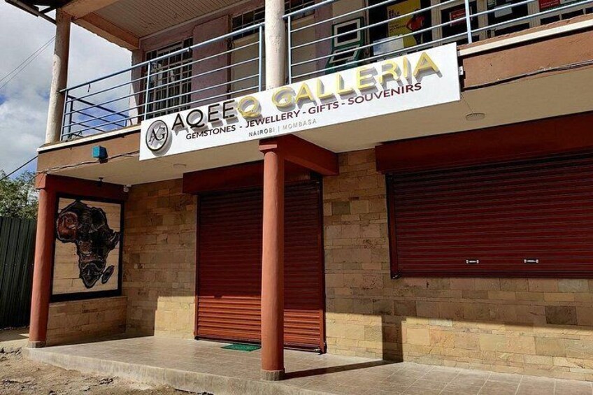 En byggnad med en skylt som visar texten ”Aquee Gallery” och en stor skulptur föreställande ett ansikte. 4