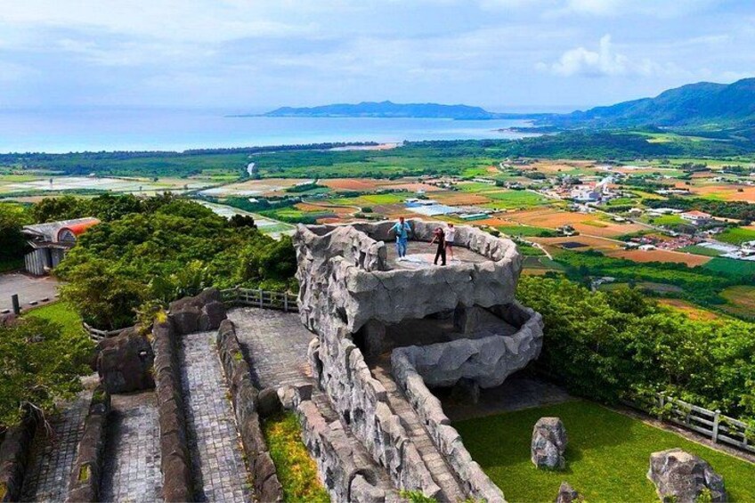 A historical stone structure with ruins and a view of a coastal landscape. 4