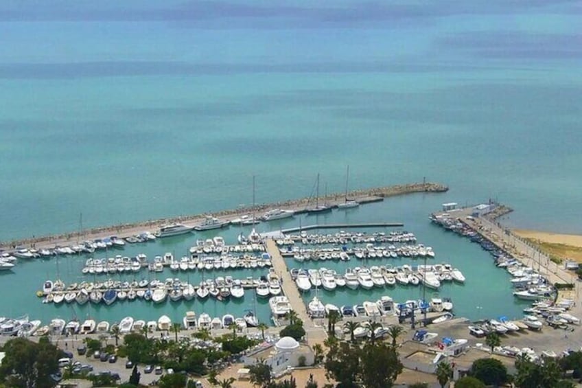A marina with numerous boats docked along a pier. 5