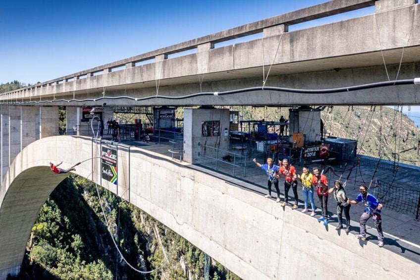 Un groupe de personnes se trouve sur un pont, avec une rivière en contrebas. 3