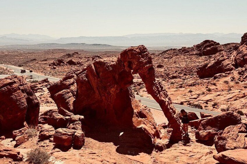 A desert landscape with a prominent rock formation and a road. 2