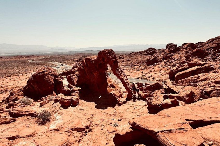 A rocky desert landscape with prominent red rock formations and a clear sky. 4