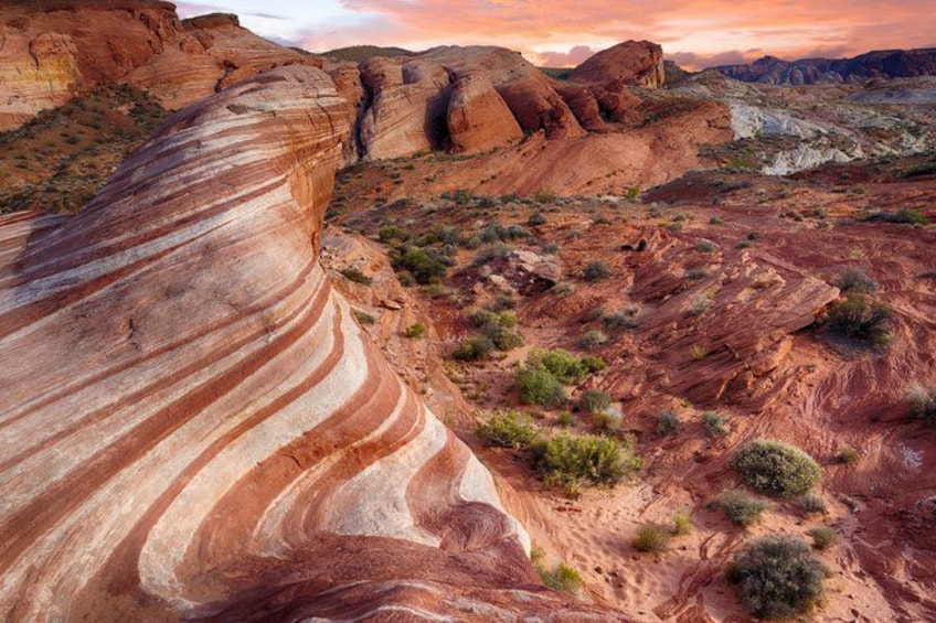 A desert landscape with layered rock formations and sparse vegetation. 2