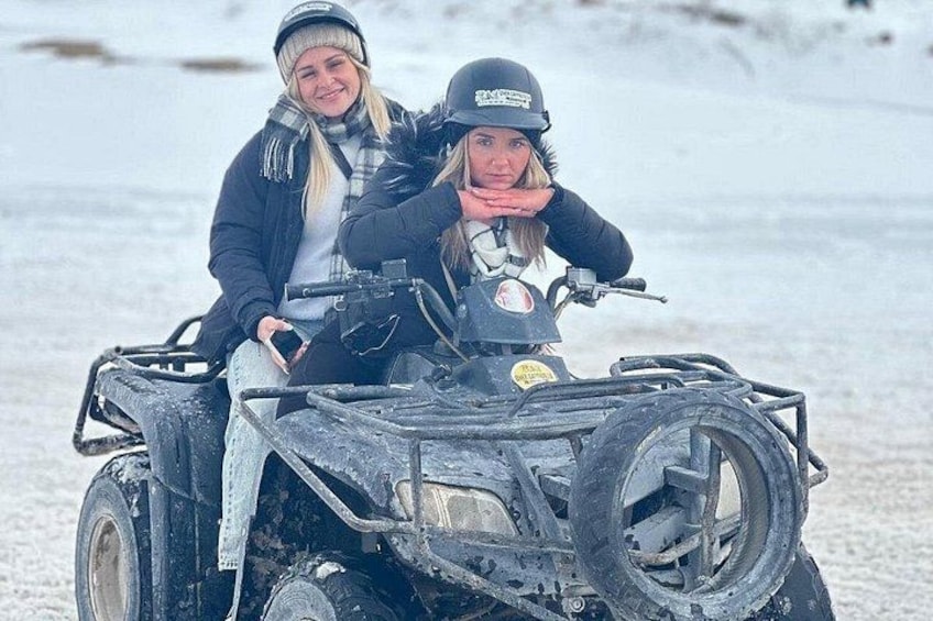 To personer på en snedækket ATV i et sneklædt landskab. 3