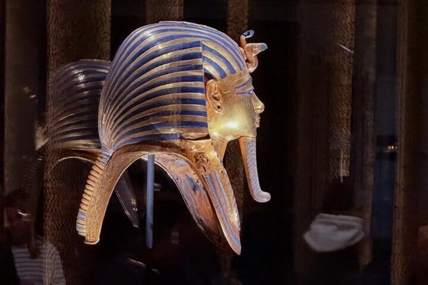 A golden Egyptian sarcophagus with a striped headdress and a cobra head. 4