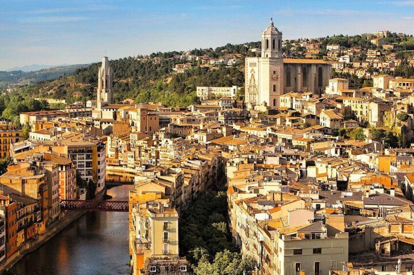 Un paisaje urbano con un río, edificios históricos y una iglesia destacada con un campanario. 3