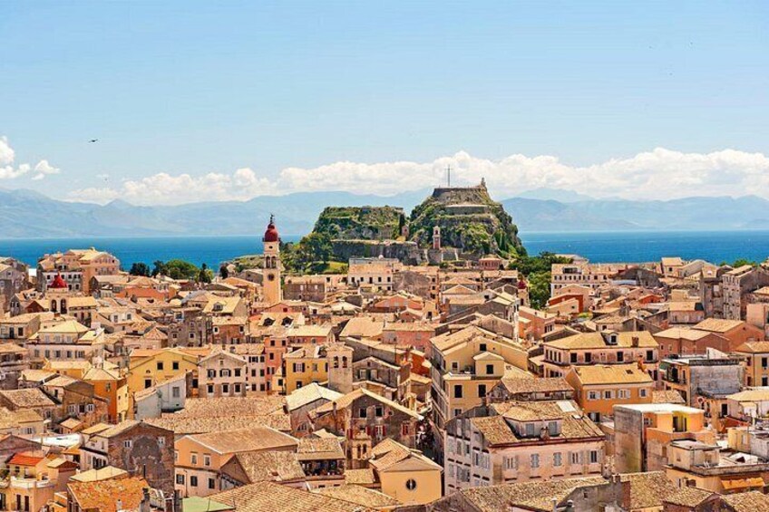 A coastal town with historic buildings, a prominent church, and a hilltop fortress. 4