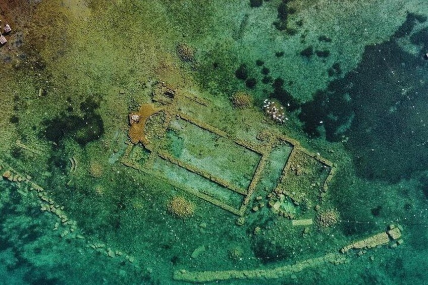 An aerial view of a submerged archaeological site with visible structures and artifacts. 3