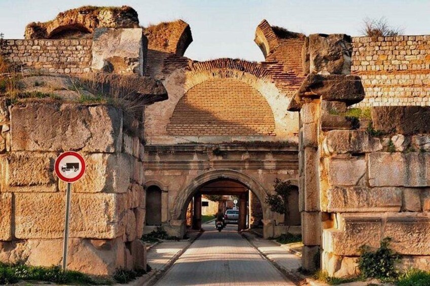 Un antiguo arco de piedra con un cartel de prohibido el paso para vehículos. 1