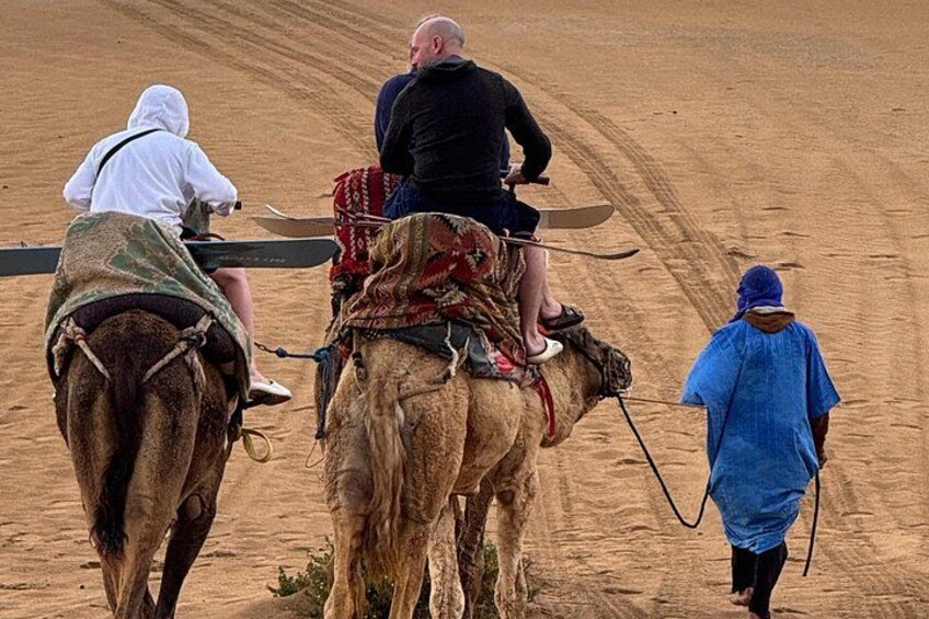 Tres camellos con jinetes en un paisaje desértico. 3