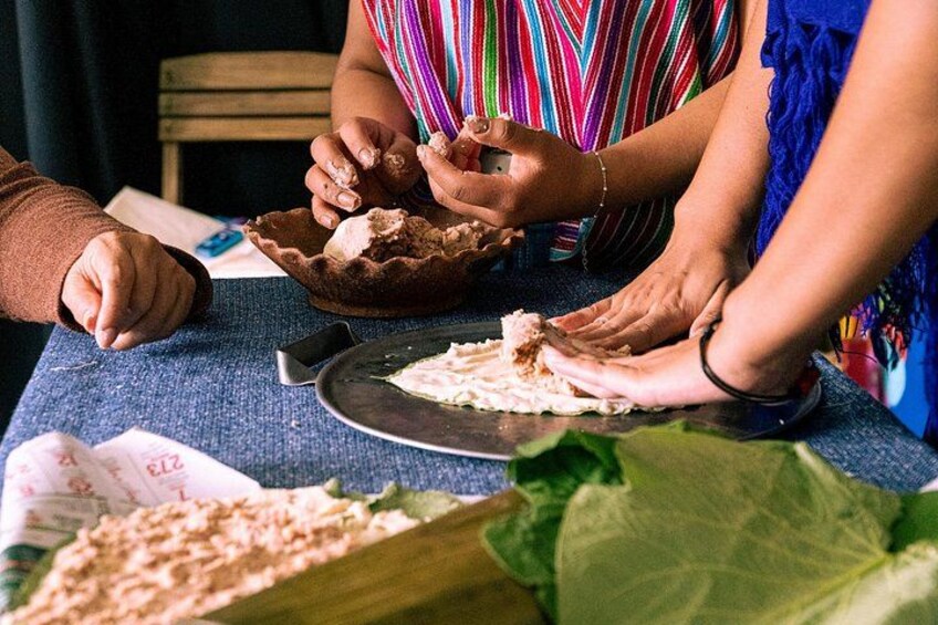 Personas preparando comida, con énfasis en manos manipulando ingredientes y una tabla de cortar. 4