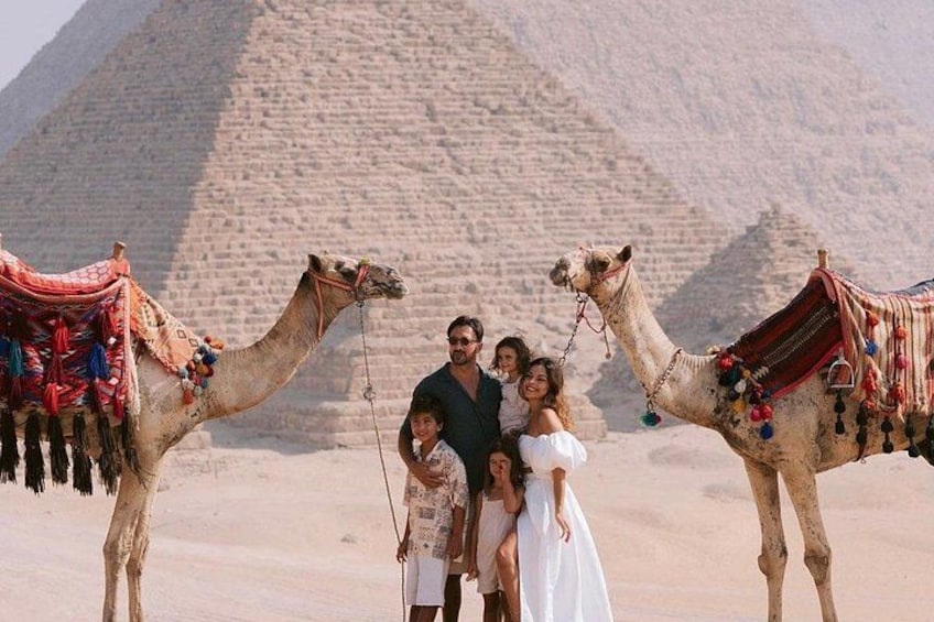 A family with camels in front of a pyramid. 5