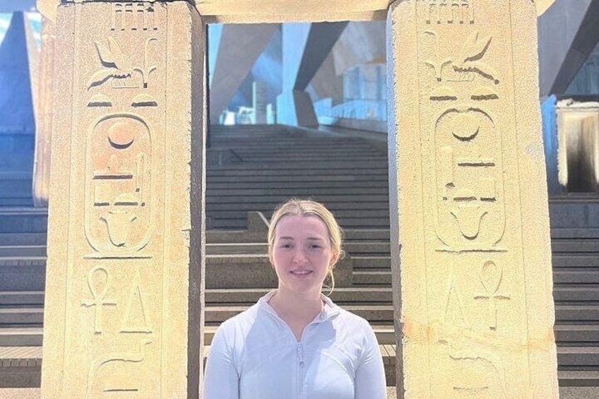 Eine Person steht vor antiken ägyptischen Hieroglyphensäulen. 5