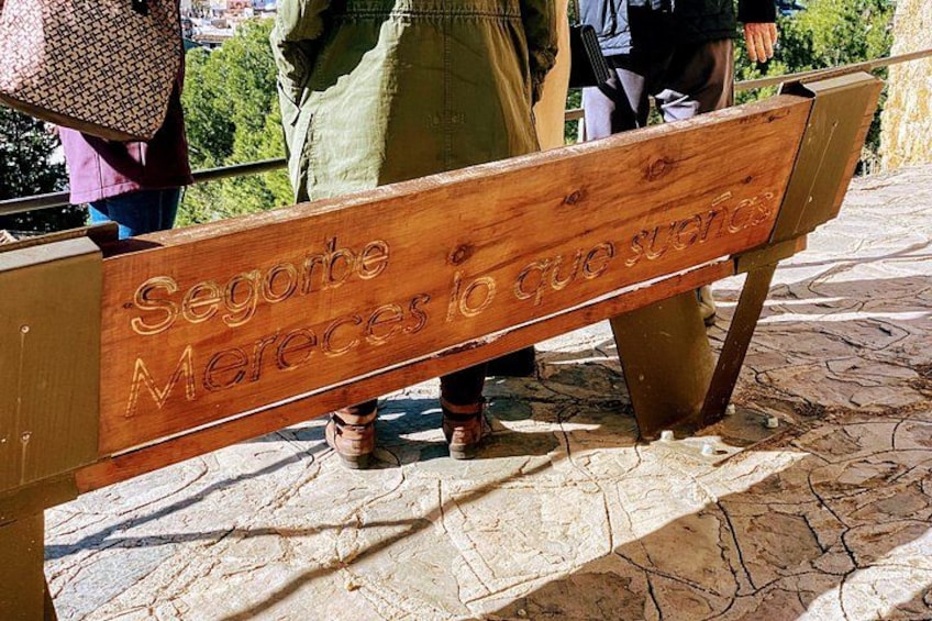 A wooden bench with engraved text. 3
