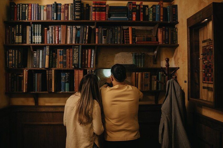 Una pareja mirando una estantería llena de libros. 2