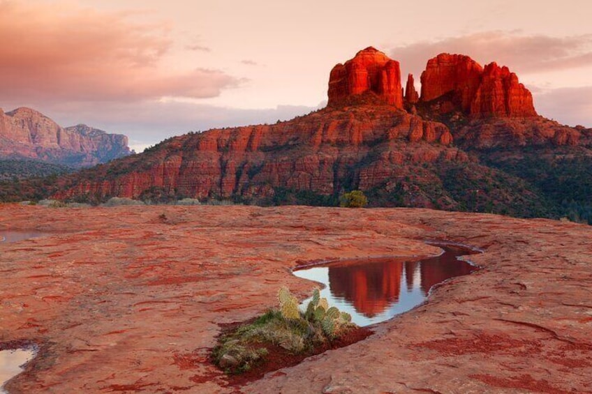 Paisaje desértico con formaciones rocosas rojas y una pequeña masa de agua. 4