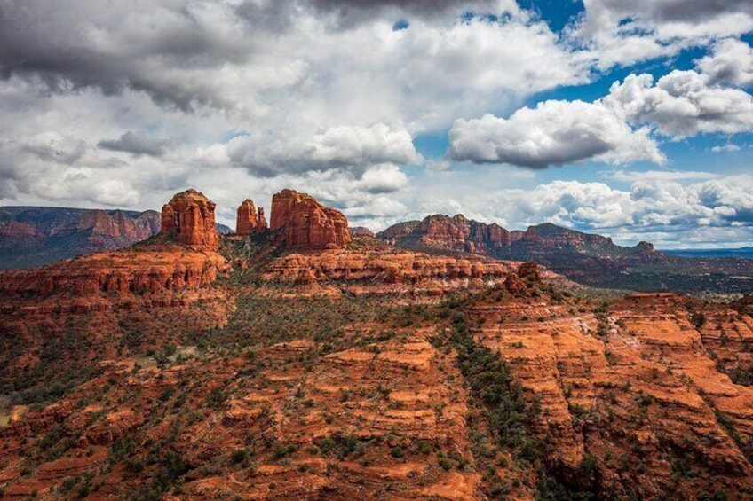 Paisaje desértico con formaciones rocosas rojas prominentes y un cielo nublado. 5