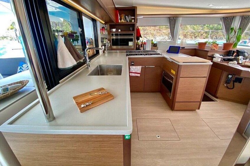 A compact kitchen with a sink, stove, and wooden countertop. 3