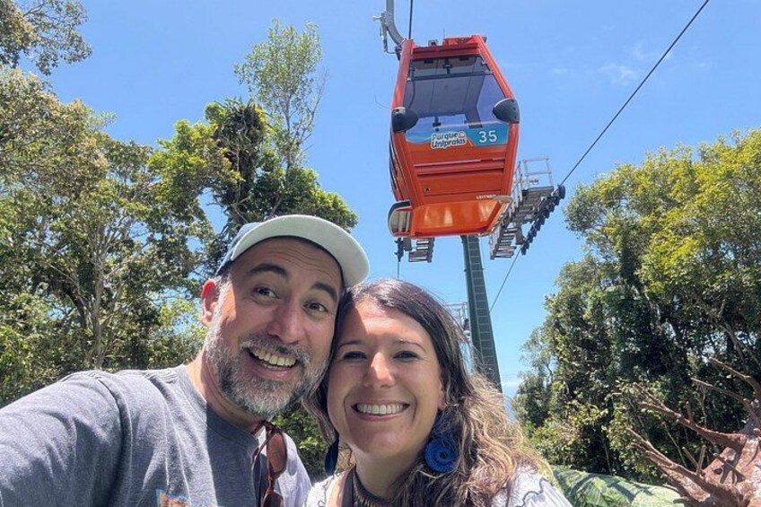 A person taking a selfie with a cable car in the background. 1