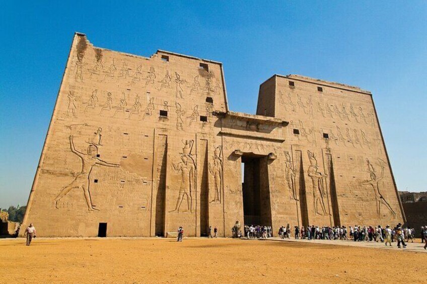 A large ancient Egyptian temple with hieroglyphics and statues. 1