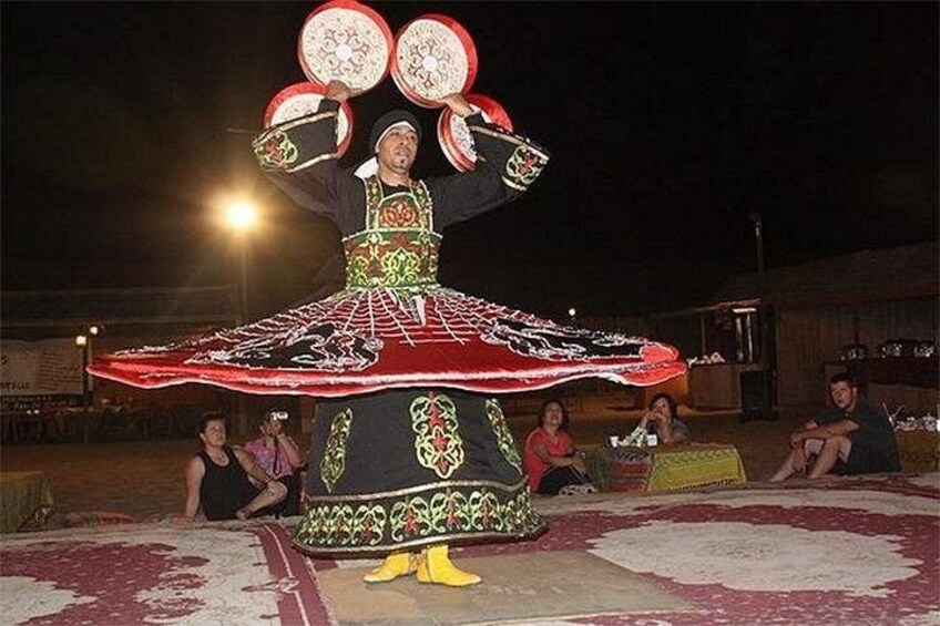 A person performing a traditional dance with a large, decorated skirt. 5
