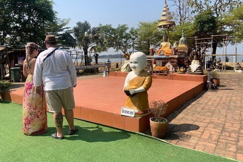 En Buddha-staty, ett pagodtempel och en vattenyta. 5