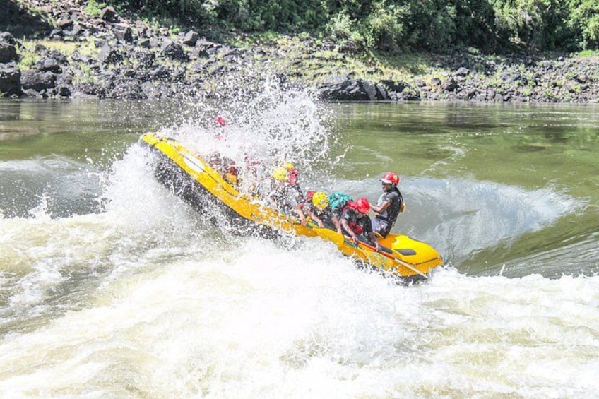 Een gele vlot met meerdere passagiers op een rivier. 3