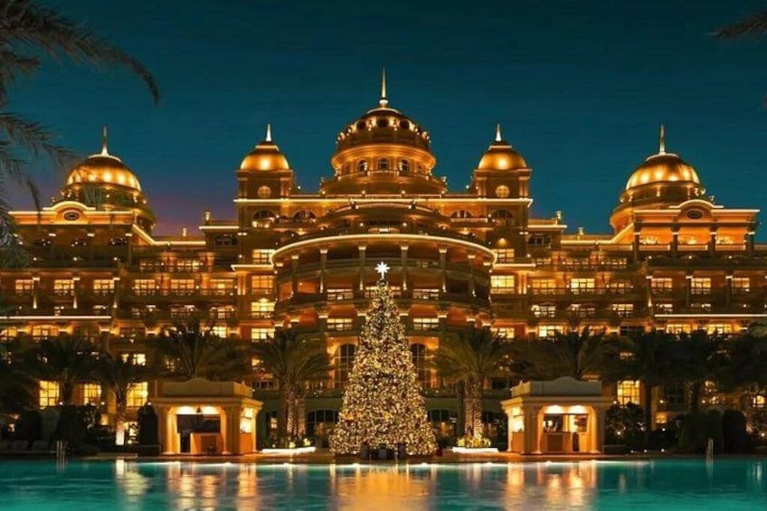 A grand hotel with multiple domes and a swimming pool in front. 2
