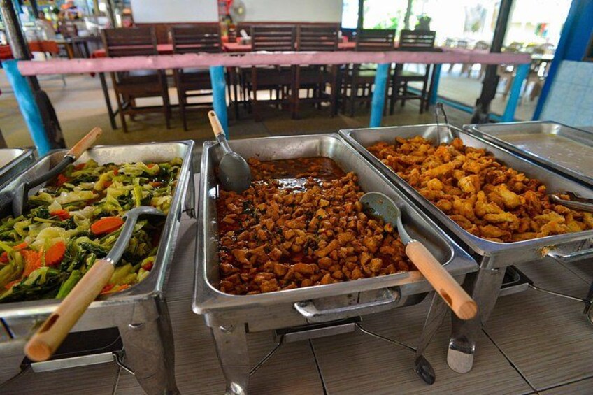 A buffet with various food options, including vegetables, a meat dish, and a rice dish. 2