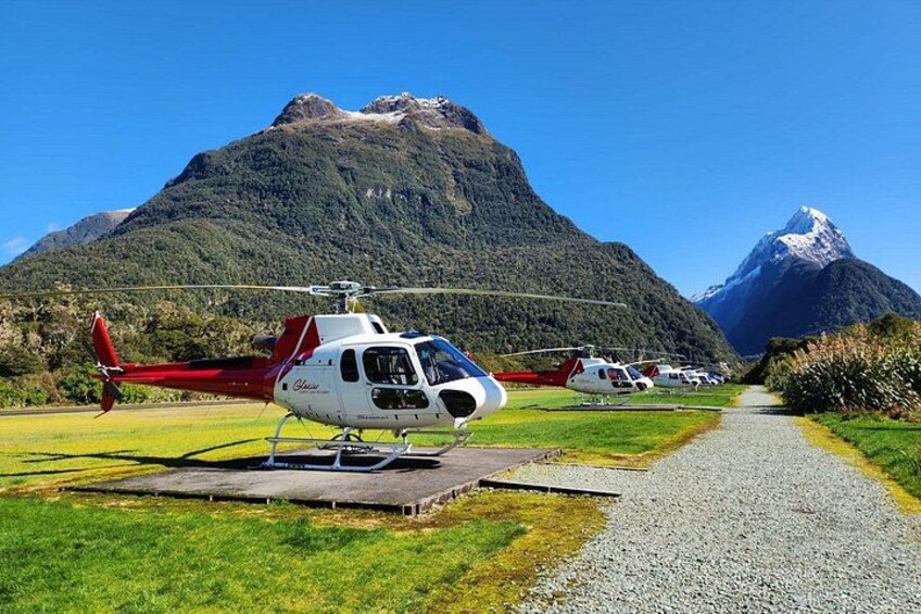 A helicopter on a helipad with a mountainous landscape in the background. 2