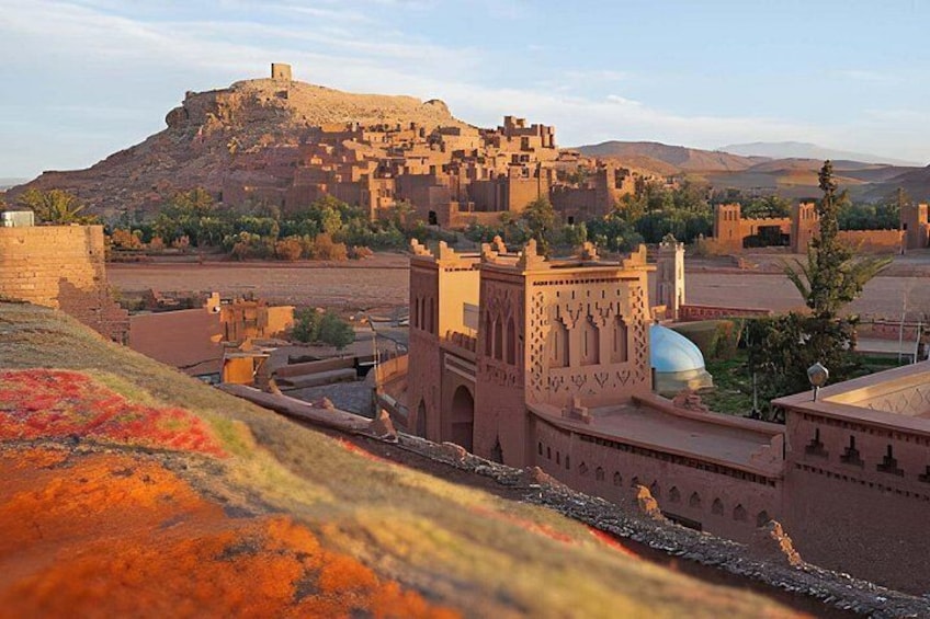 A historic fortified city with a prominent hilltop castle, traditional architecture, and a mosque with a dome. 1