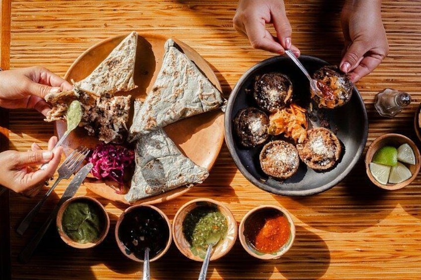 Comida con tortillas, albóndigas y diferentes salsas sobre una mesa de madera. 1