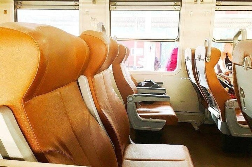 A train interior with leather seats and overhead luggage compartments. 5