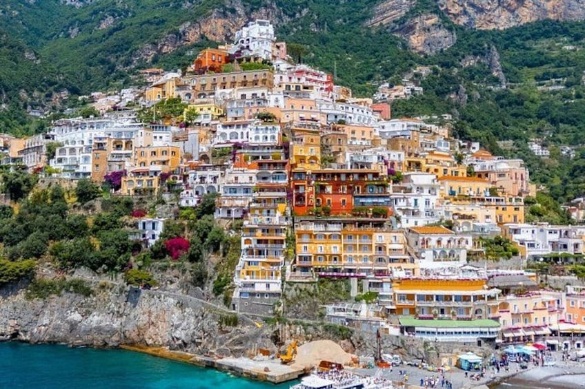 Una pittoresca cittadina costiera con edifici colorati costruita su una collina, affacciata sul mare. 2