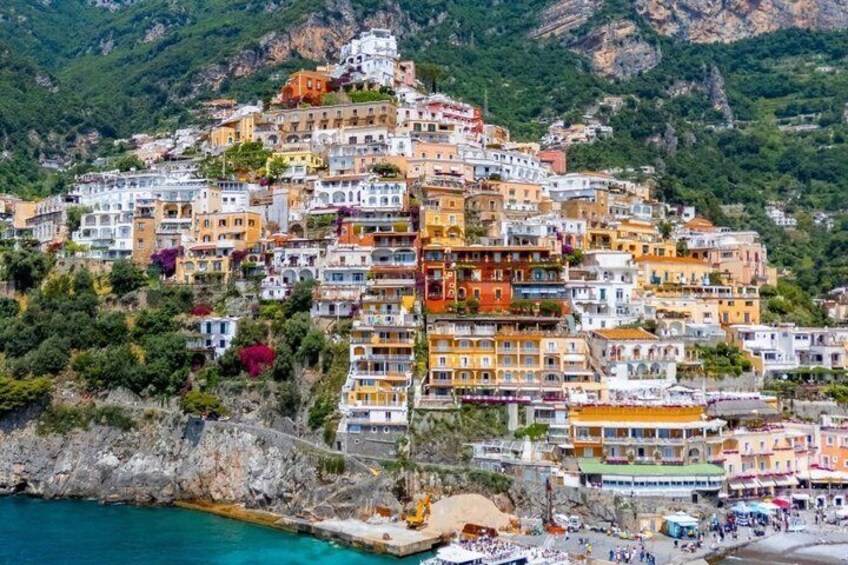 Une ville côtière aux bâtiments aux couleurs vives, adossée à une colline. 2