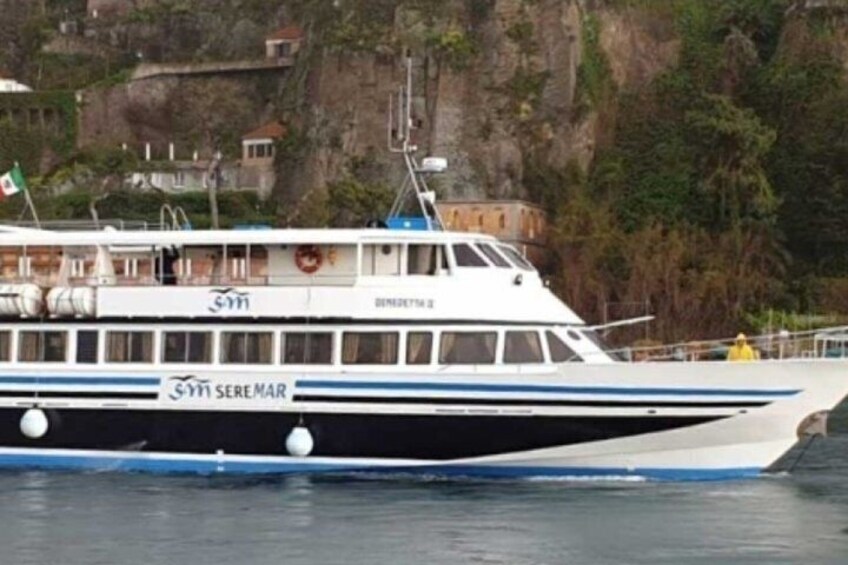 Un bateau nommé « Seremar », orné d’une bande bleue, était amarré près d’une côte rocheuse, avec des bâtiments visibles à l’arrière-plan. 3
