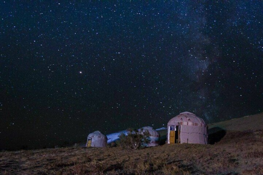 Cielo estrellado con un observatorio en forma de cúpula y una cúpula más pequeña sobre una colina cubierta de hierba. 1