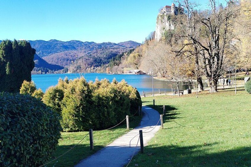 Un sentier qui mène à un lac, avec des montagnes en arrière-plan et un château perché sur une colline. 5