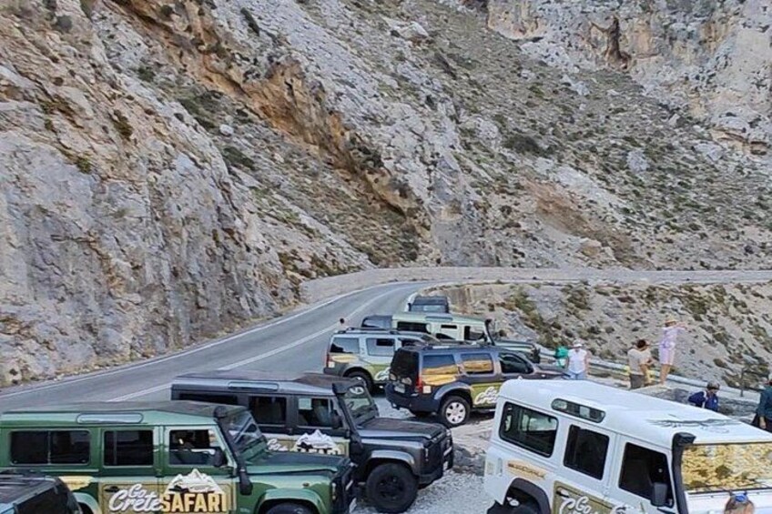A convoy of vehicles parked on a winding mountain road. 4