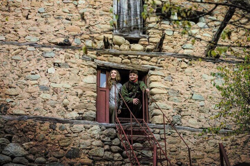 Un bâtiment en pierre avec une fenêtre et une échelle en bois. 5